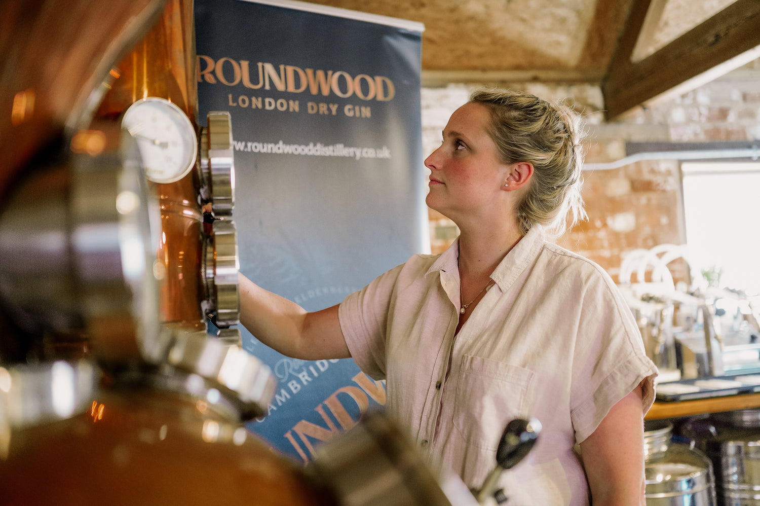 Emily inspects the temperature dials on the column of copper still Bluebelle